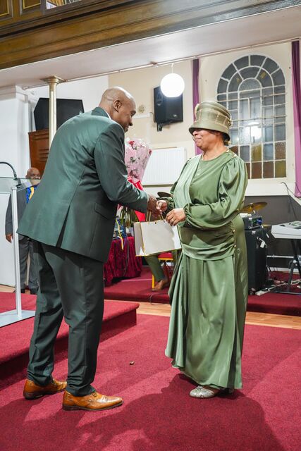 Man and woman standing opposite one another at the front of the church.